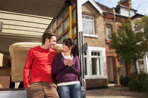 Professional movers handling furniture and IT equipment during an office relocation